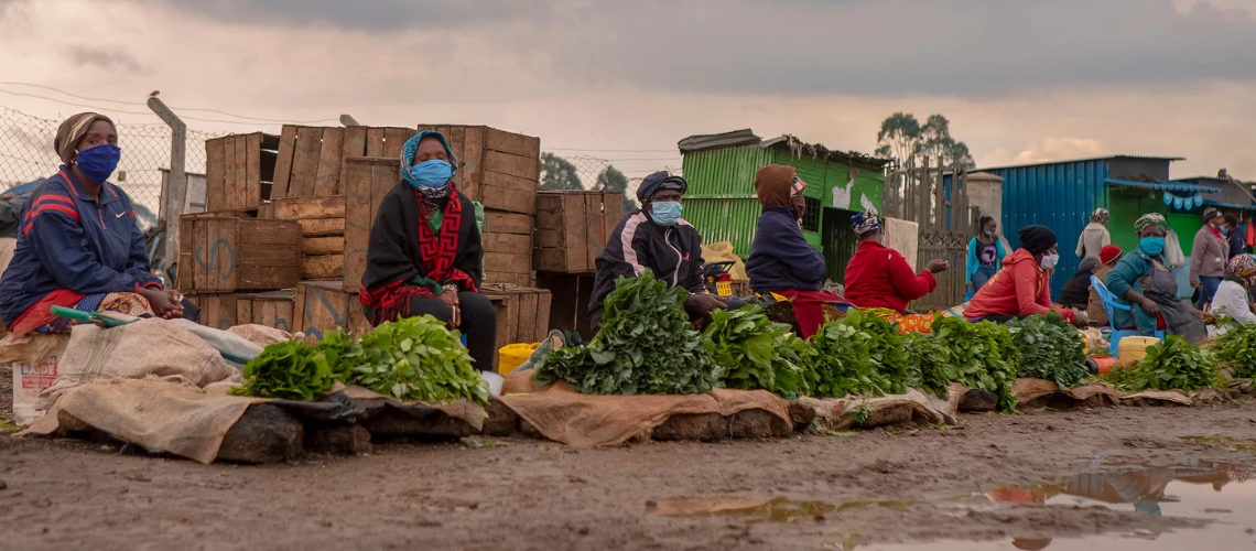 Photo of masked women selling food at the side of the road: World Bank/Sambrian Mbaabu