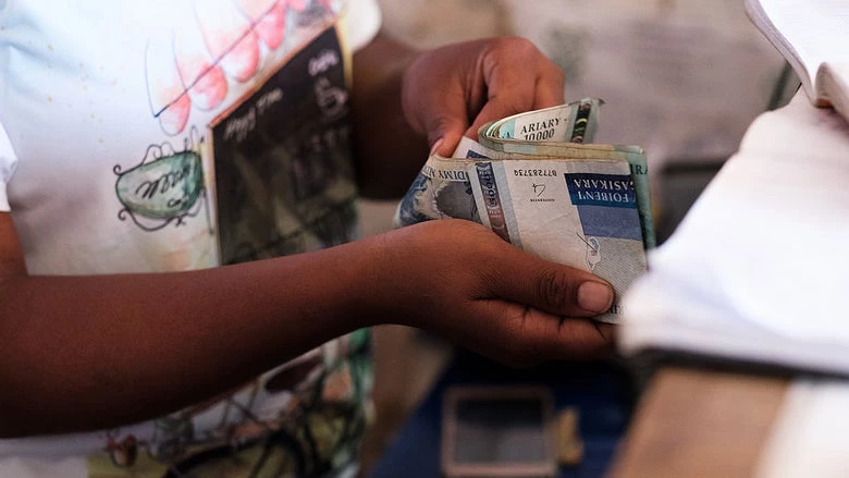 Soahanginirina Razafindrahanta, a teller at a Baobab bank outlet counting out money for a customer in Antananarivo, Madagascar. © Nyani Quarmyne/International Finance Corporation