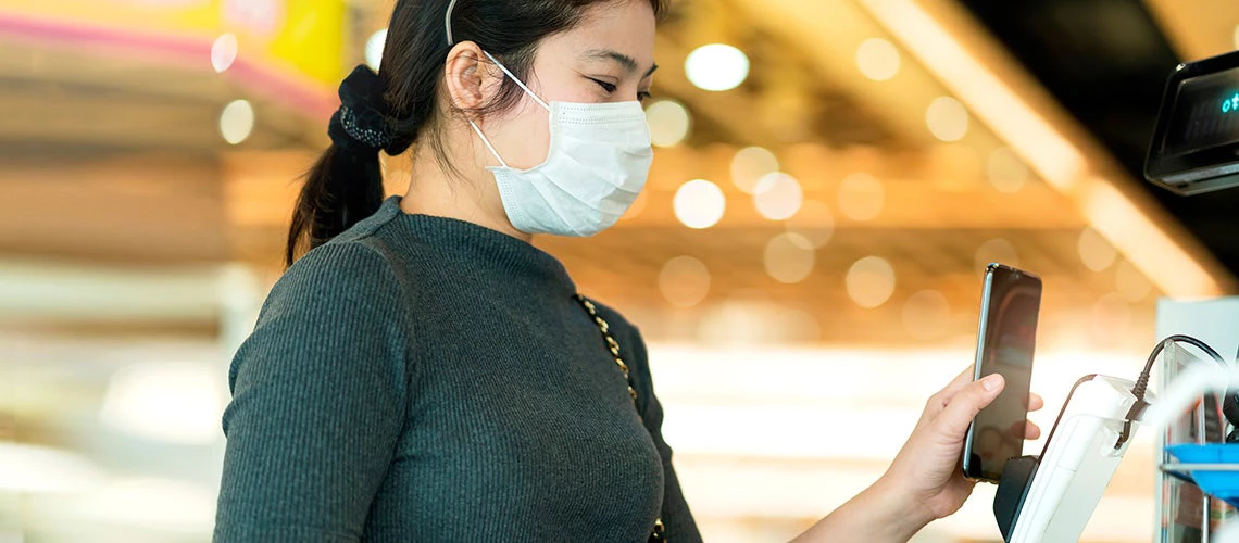 A female conducting a transaction using her smart phone | © shutterstock.com