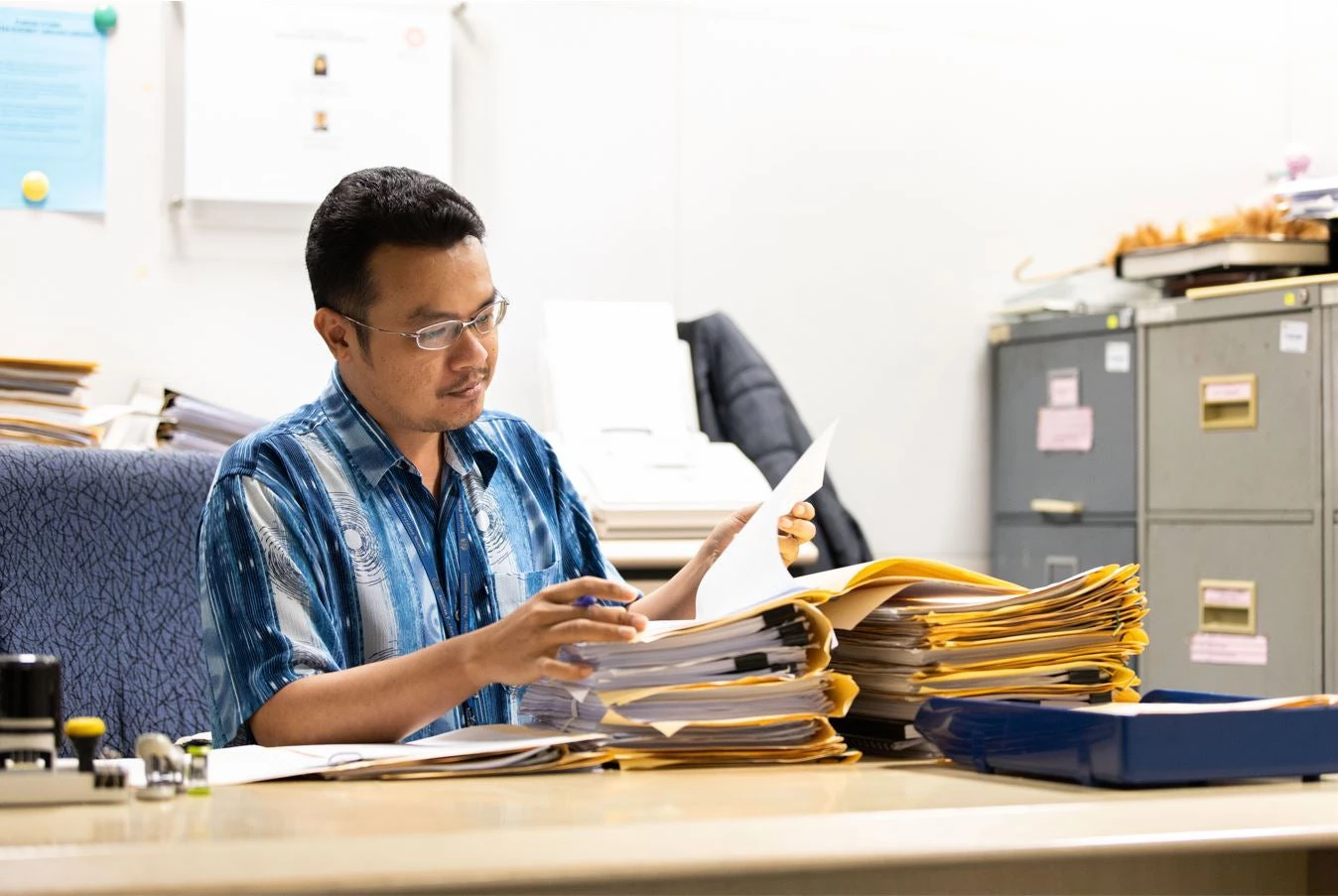 A government office staff working on paperwork in his office