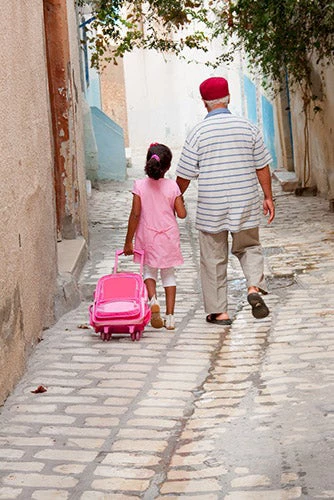  Lyubov Timofeyeva | Shutterstock.com - Grandfather and granddaughter walking back from school in Sousse, Tunisia