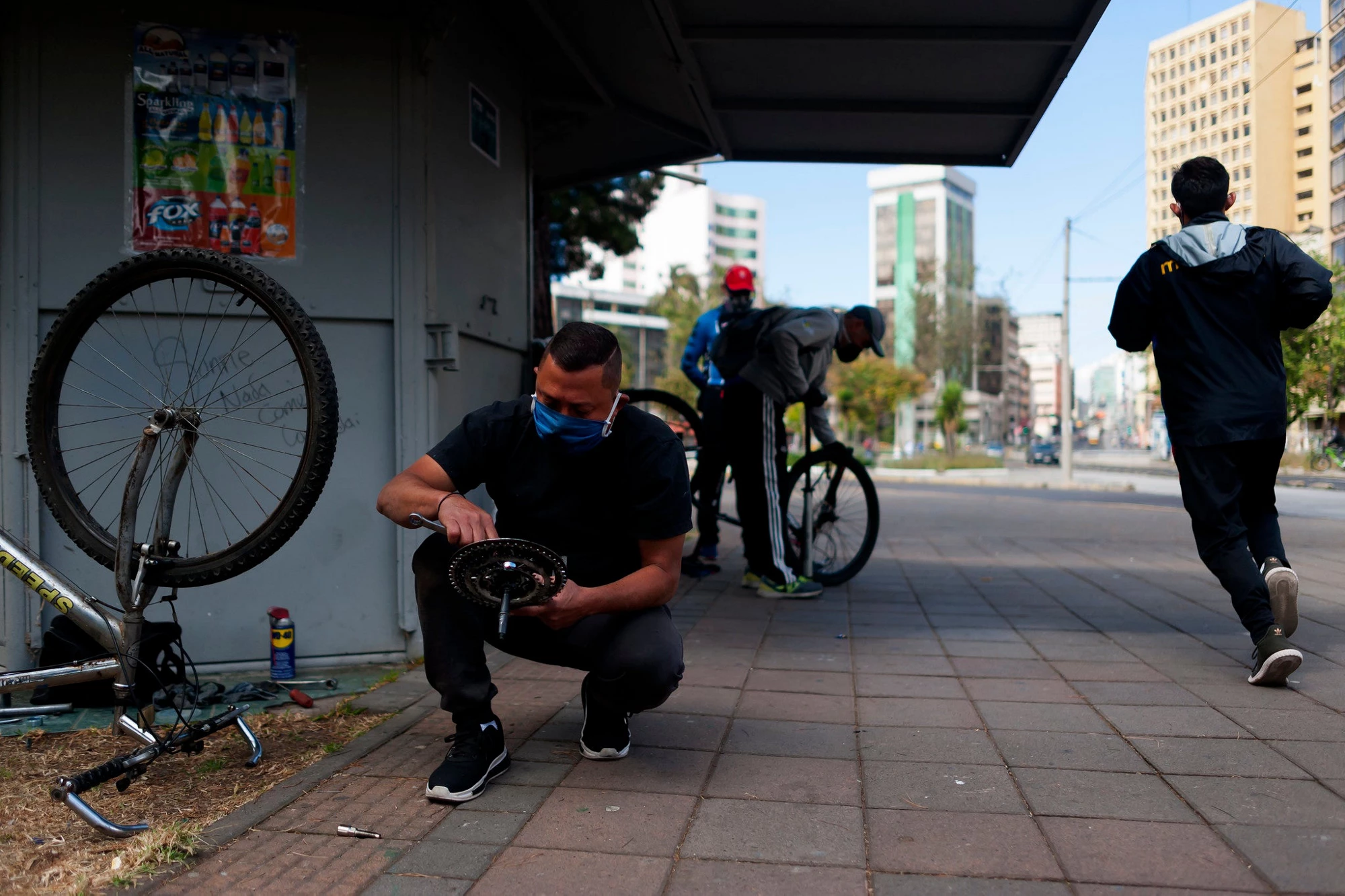 Migrantes venezolanos reparan bicicletas en Quito, Ecuador.