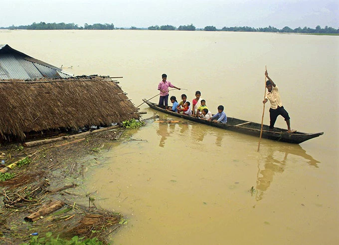 Flood-affected local residents move to safer places on a boat next to their damaged huts after heavy rains at Jajimukh village in the northeastern Indian state of Assam June 27, 2012. Incessant heavy rains in northeast India have caused massive flooding and landslides, killing at least 10 people.