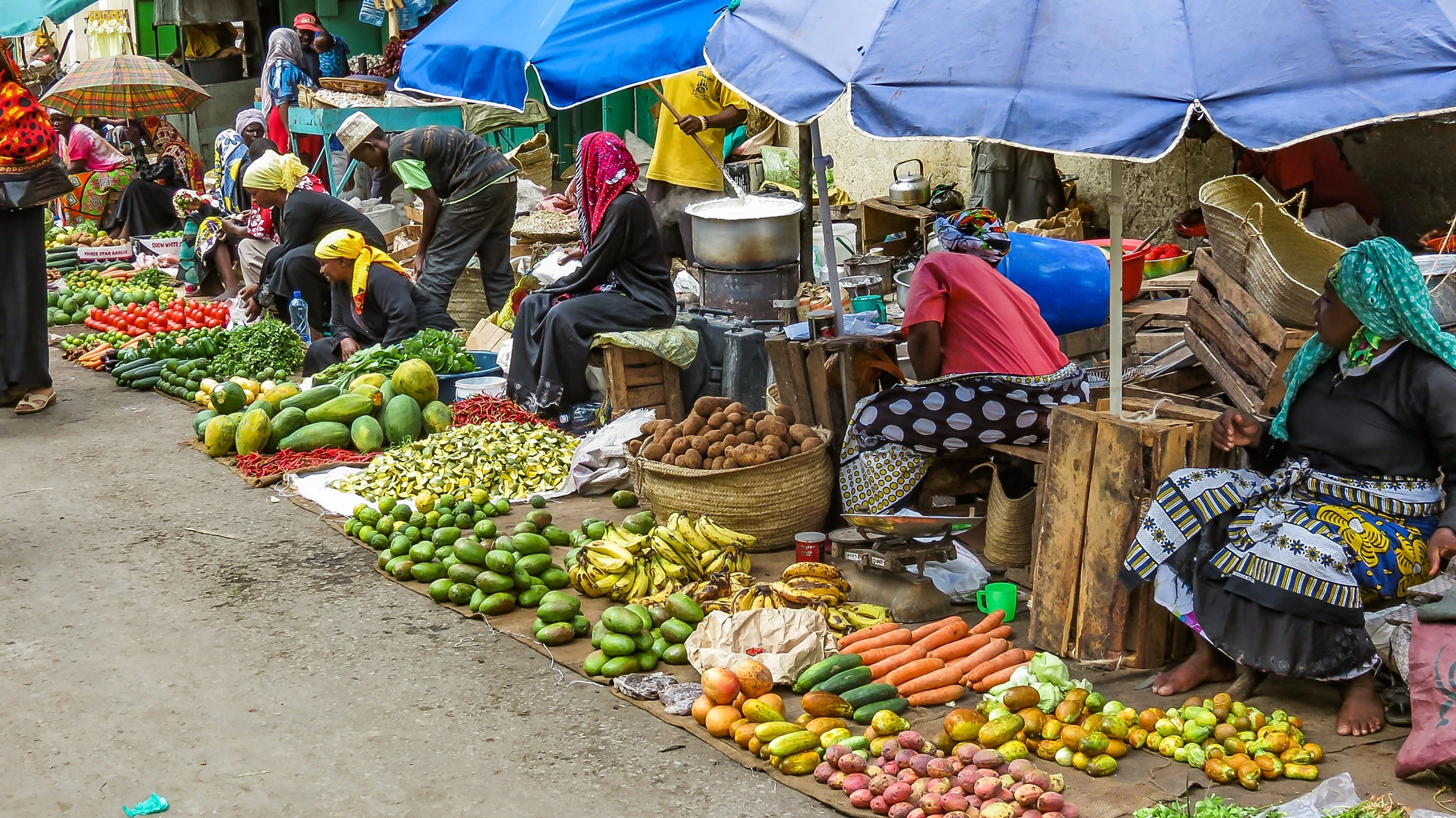 Mombasa, Kenya: Group of poor women selling vegetables and fruits on a street