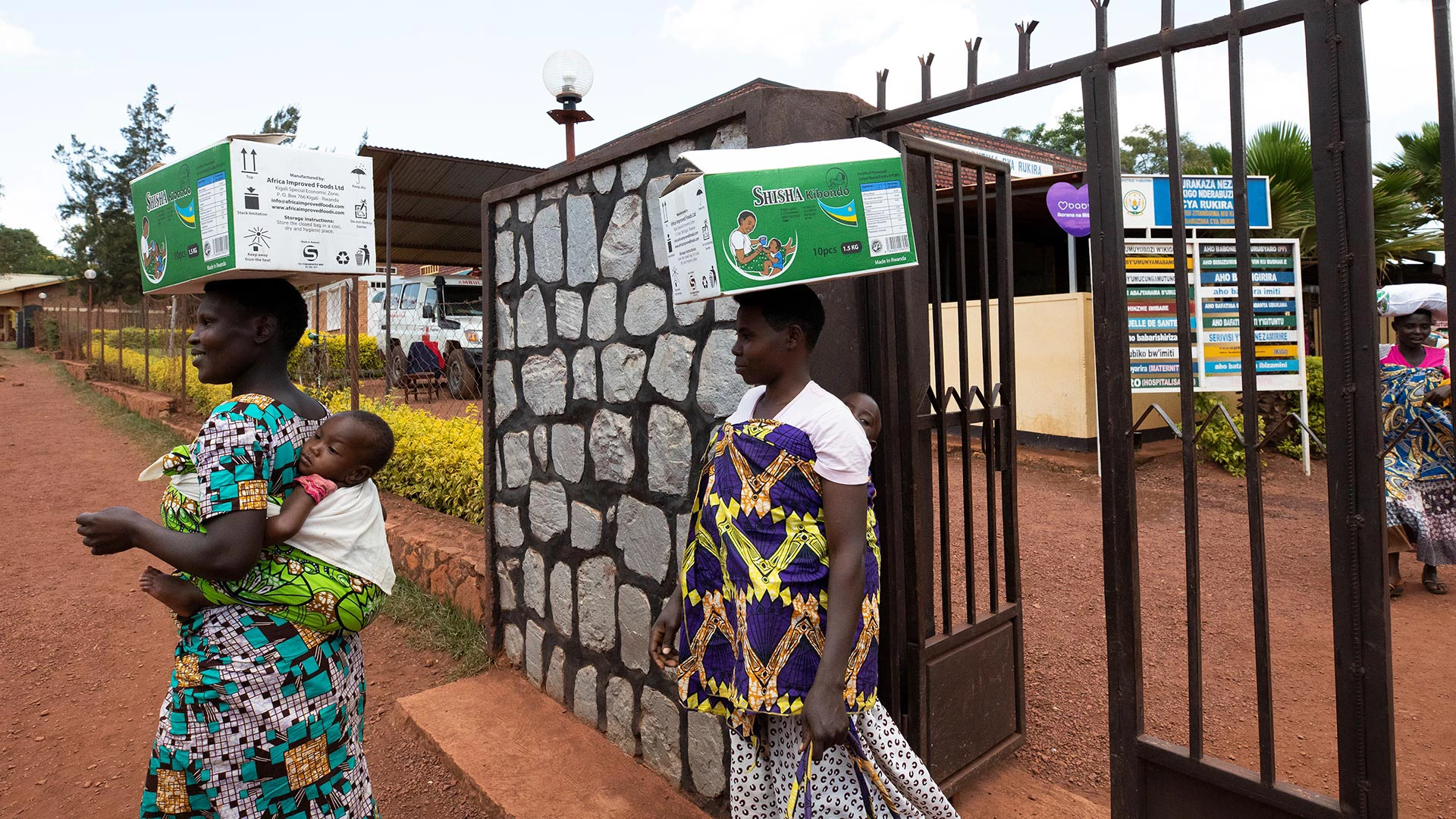 Solange Uwingeneye, (à gauche) mère de jumeaux, reçoit une boîte d'aliments fortifiés au centre de santé de Rukina dans le village de Rikina, au Rwanda, le 22 mars 2019. Photo © Dominic Chavez/IFC