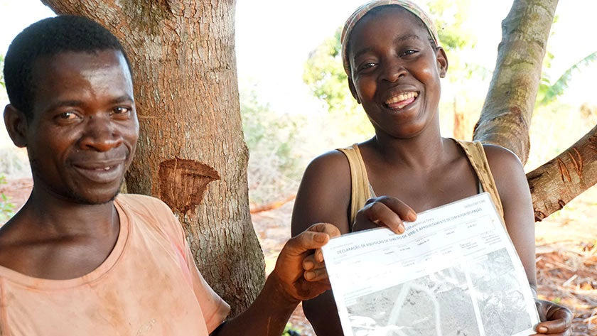 Ácia and Patrício holding the documentation of their property boundary.