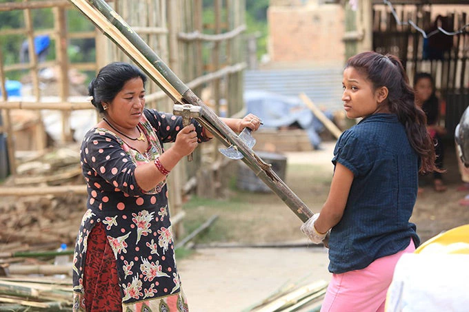 Mujeres nepalíes reconstruyendo estructuras de viviendas