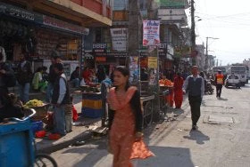 A woman walks down a busy street in Nepal
