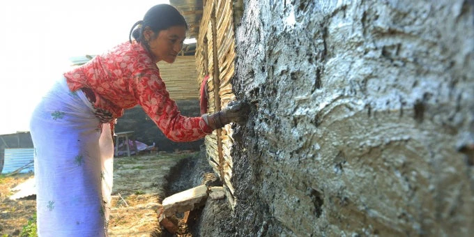 Nepali woman plasters house