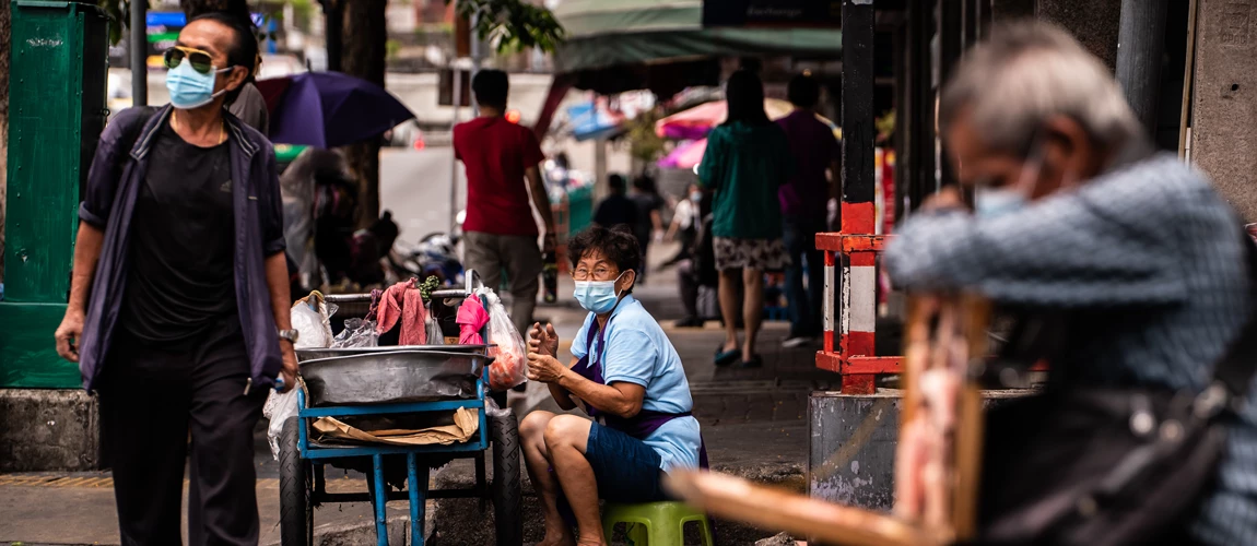 Une vendeuse de rue thaïlandaise portant un masque de protection à Bangkok