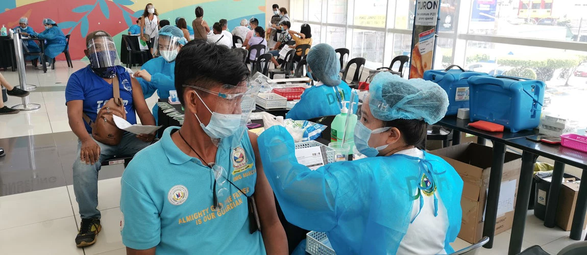Las Pinas, Metro Manila, Philippines - June 2021: People get their first dose of Pfizer-BioNTech COVID-19 vaccine at a mass vaccination area setup at a local mall.