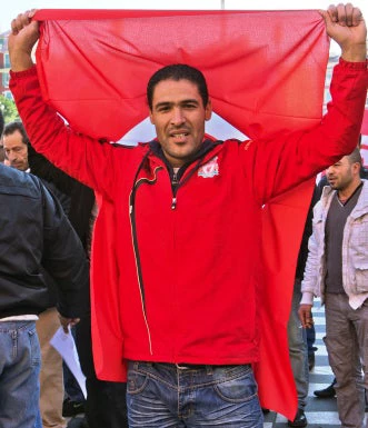 Man holding Tunisian Flag - jbor / Shutterstock.com