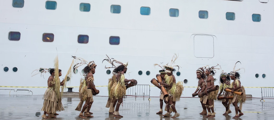 traditional dancers with tourist cruise ship