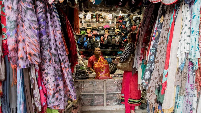 A woman purchases clothes from a store in Lalitpur, Nepal.