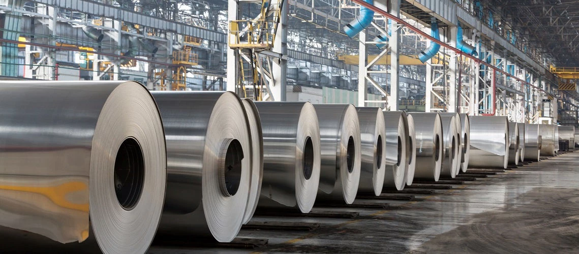 Row of rolls of aluminum lie in production shop of plant