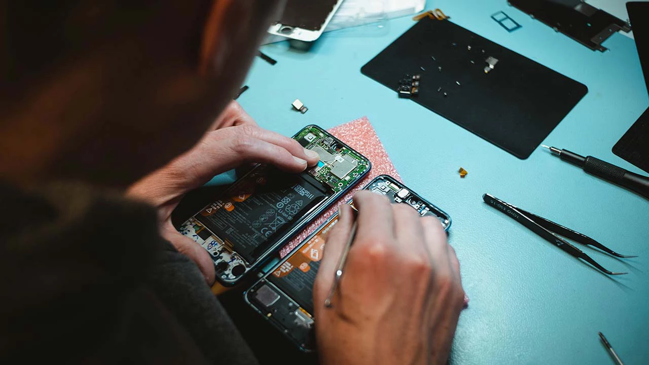 A person repairing a mobile phone.