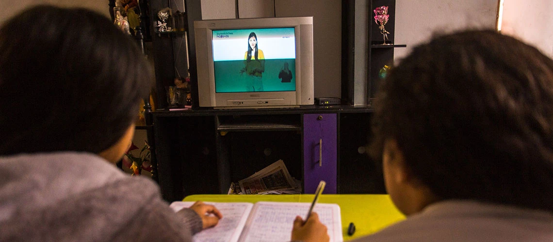 Niñas estudian juntas mirando la televisión en tiempos de pandemia en Lima, Perú. ©Victor Idrogo / Banco Mundial.
