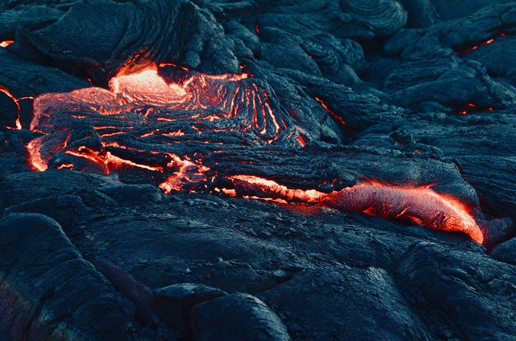Bright red and orange lava flowing down black lava rock
