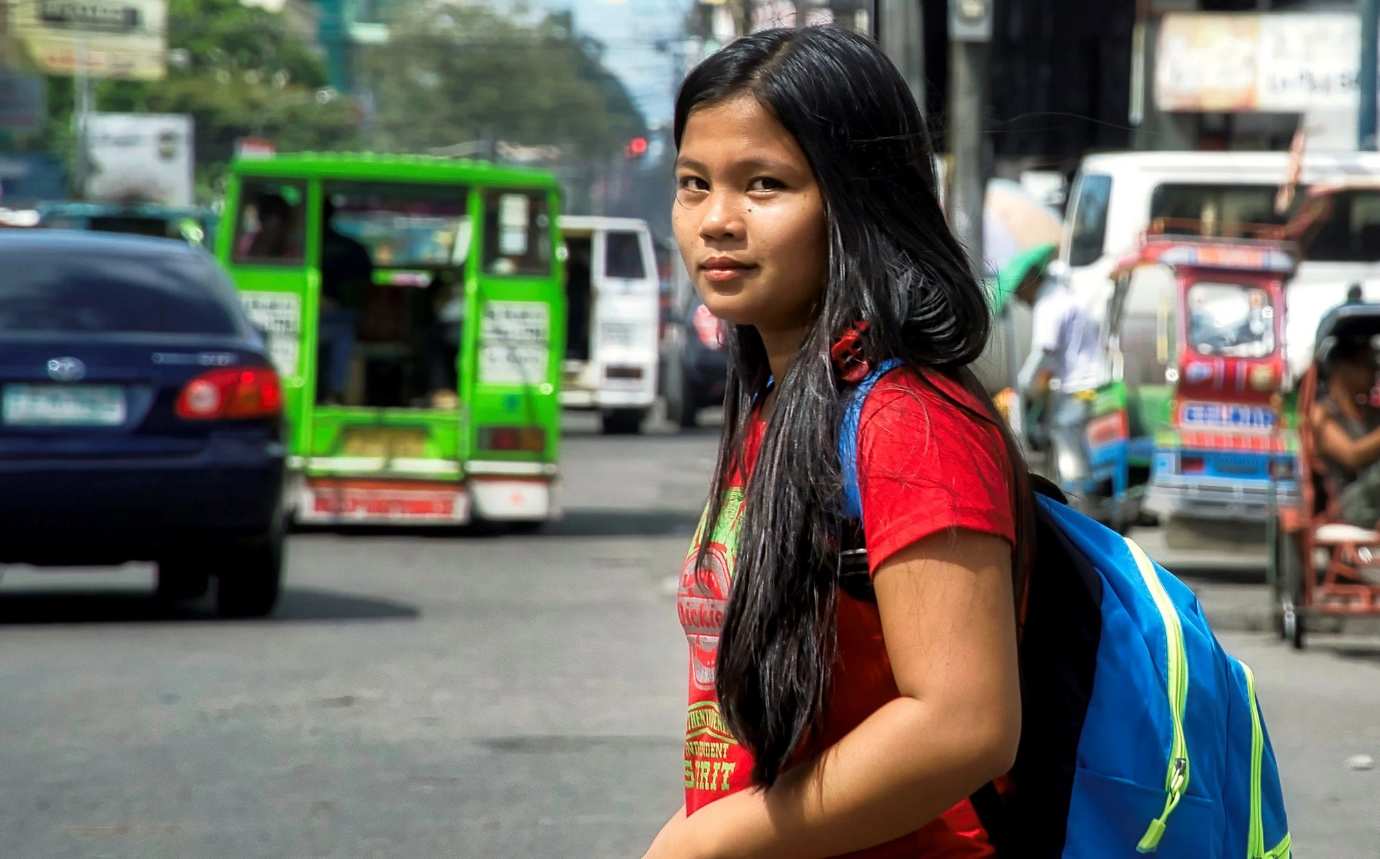 A young woman waiting to cross the street in the Philippines. Photo: Brian Evans/Flickr