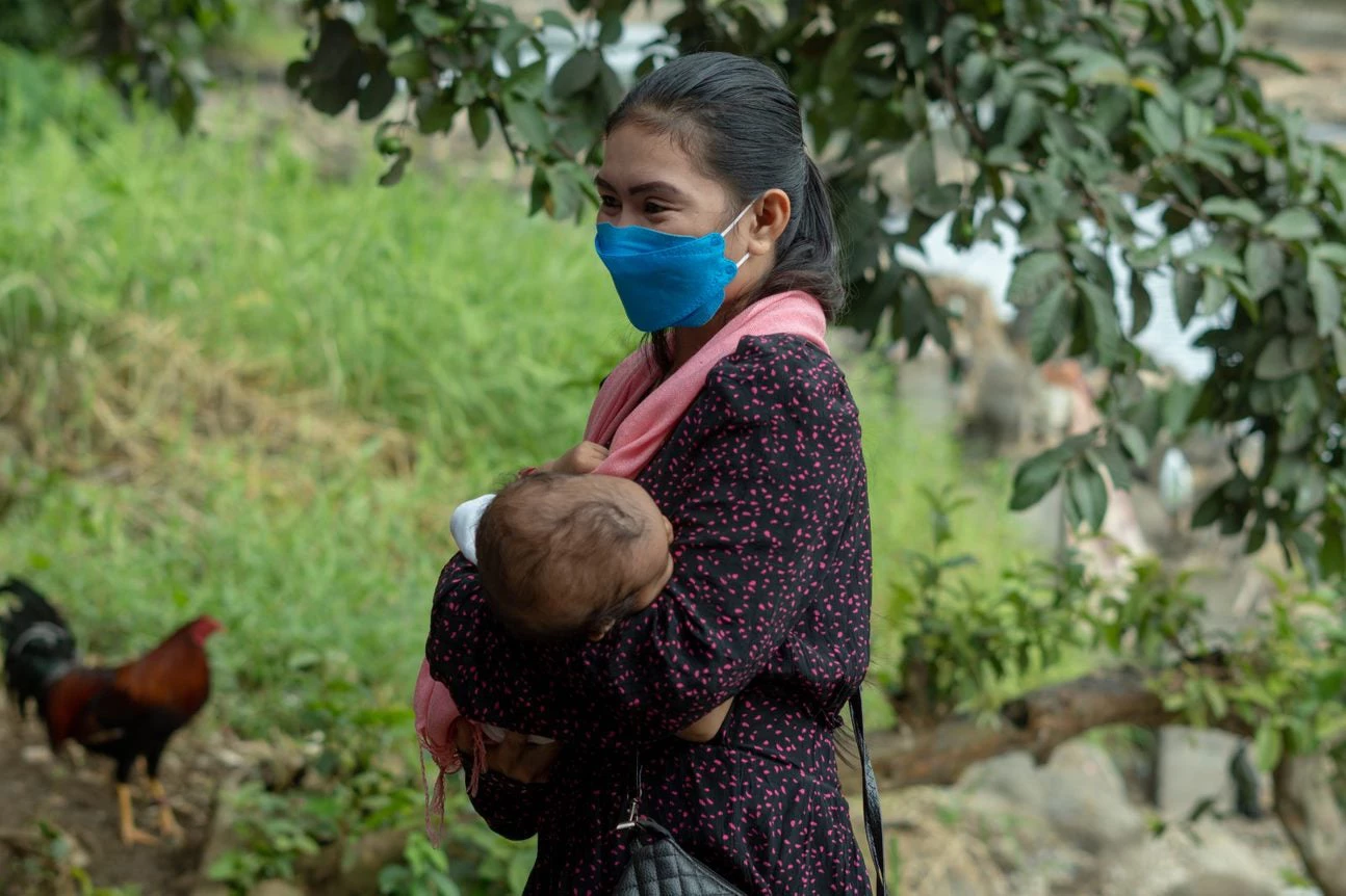 Girly, a woman from the BARMM, carries her baby at home. Just a few hours earlier, Girly received a dose of COVID-19 vaccine at the Marawi City Hall Complex in Lanao del Sur.  Photo: Remar Pablo