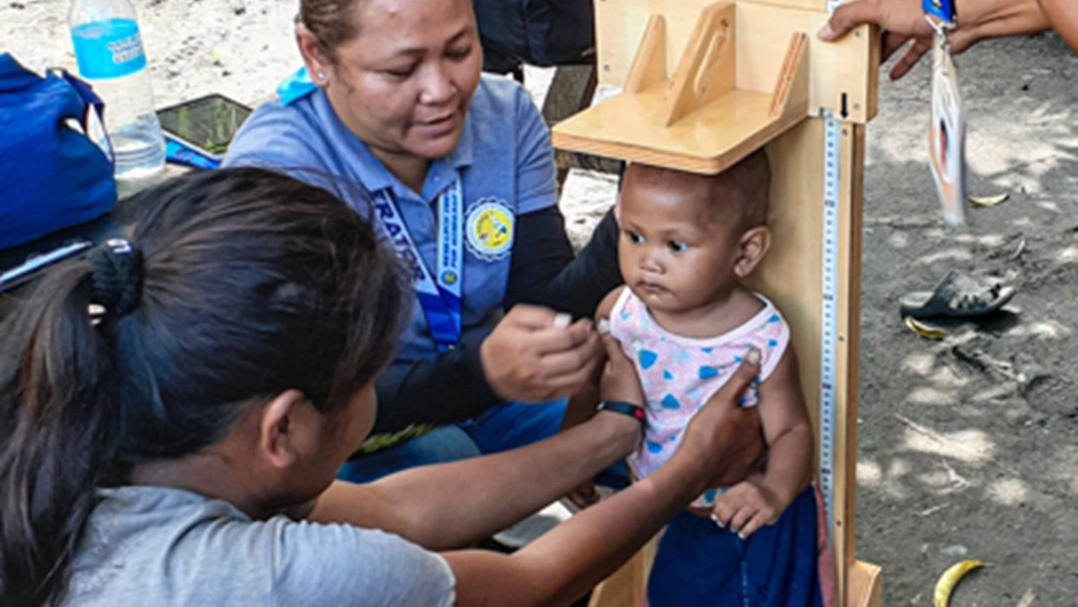 A mother helps health volunteers measure her baby?s height during a health survey in Buluan, Maguindanao