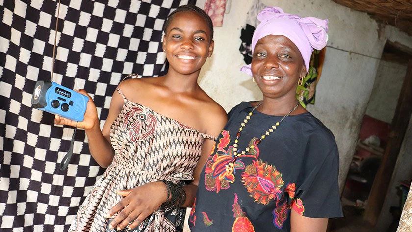 A pupil and her mother pose with a radio in appreciation of the Radio Teaching Program. © Sierra Leone Ministry of Basic and Senior Secondary Education.