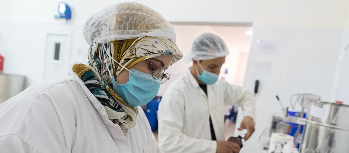 Une femme et un homme travaillent dans une usine d'huile d'argan au Maroc.