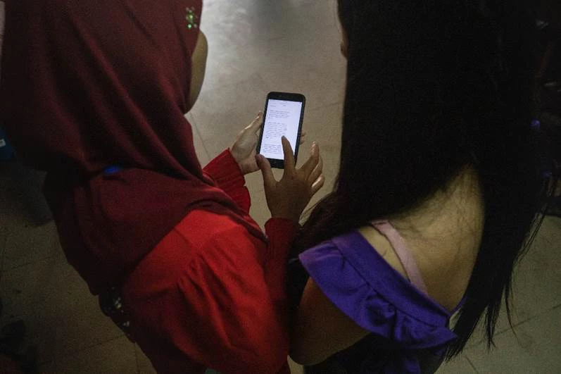 2 women look at mobile phone