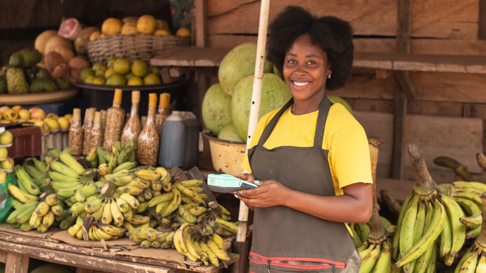 Woman using mobile payments at fruit stand in market