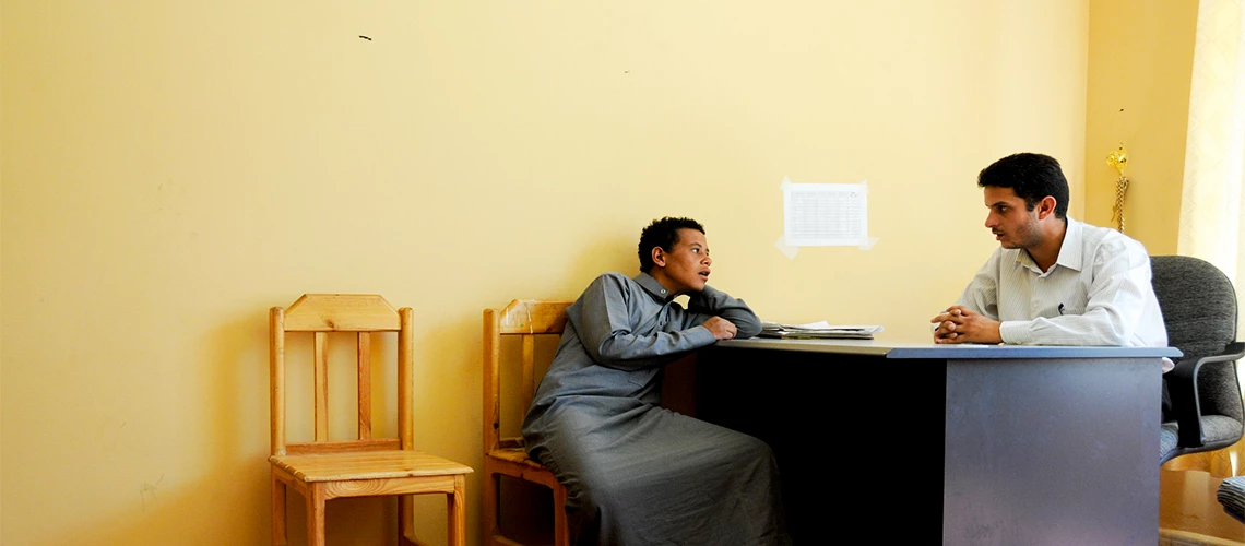 A case worker interviews a young man at a shelter for street children