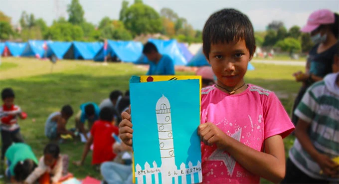 Biswash, a 12 year old staying at the temporary camp in Uttar Dhoka showing the Dharahara collage he made. 