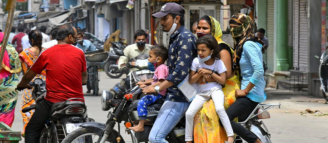 A family of five ride on a bike at a market in Rajasthan, India. 