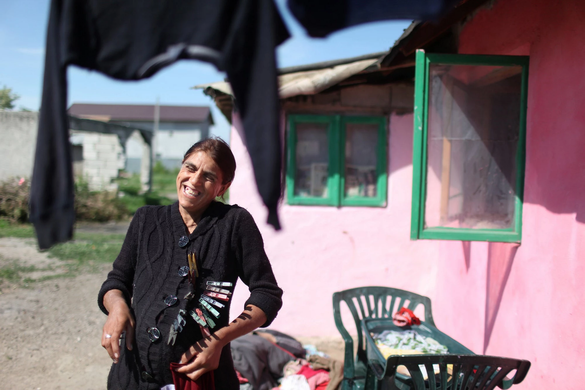 Roumanie. Nicoleta Alecu rit avec une amie tandis qu'elles font la lessive devant leur maison dans une communauté de Roms, dans le village de Frumusani. © Dominic Chavez / Banque mondiale