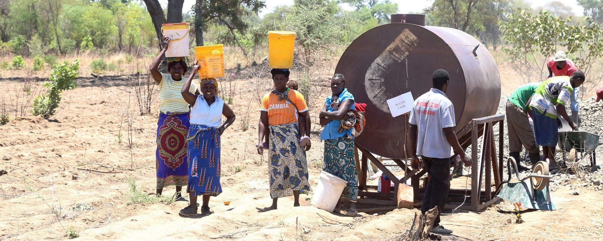 People fetching water from a water tank. Photo credit: Royd Sibajene