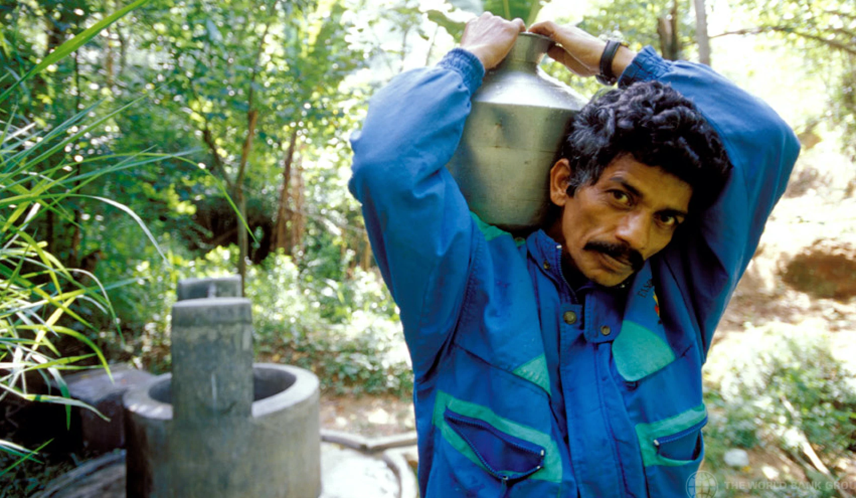 Man collecting drinking water from community well in Sri Lanka