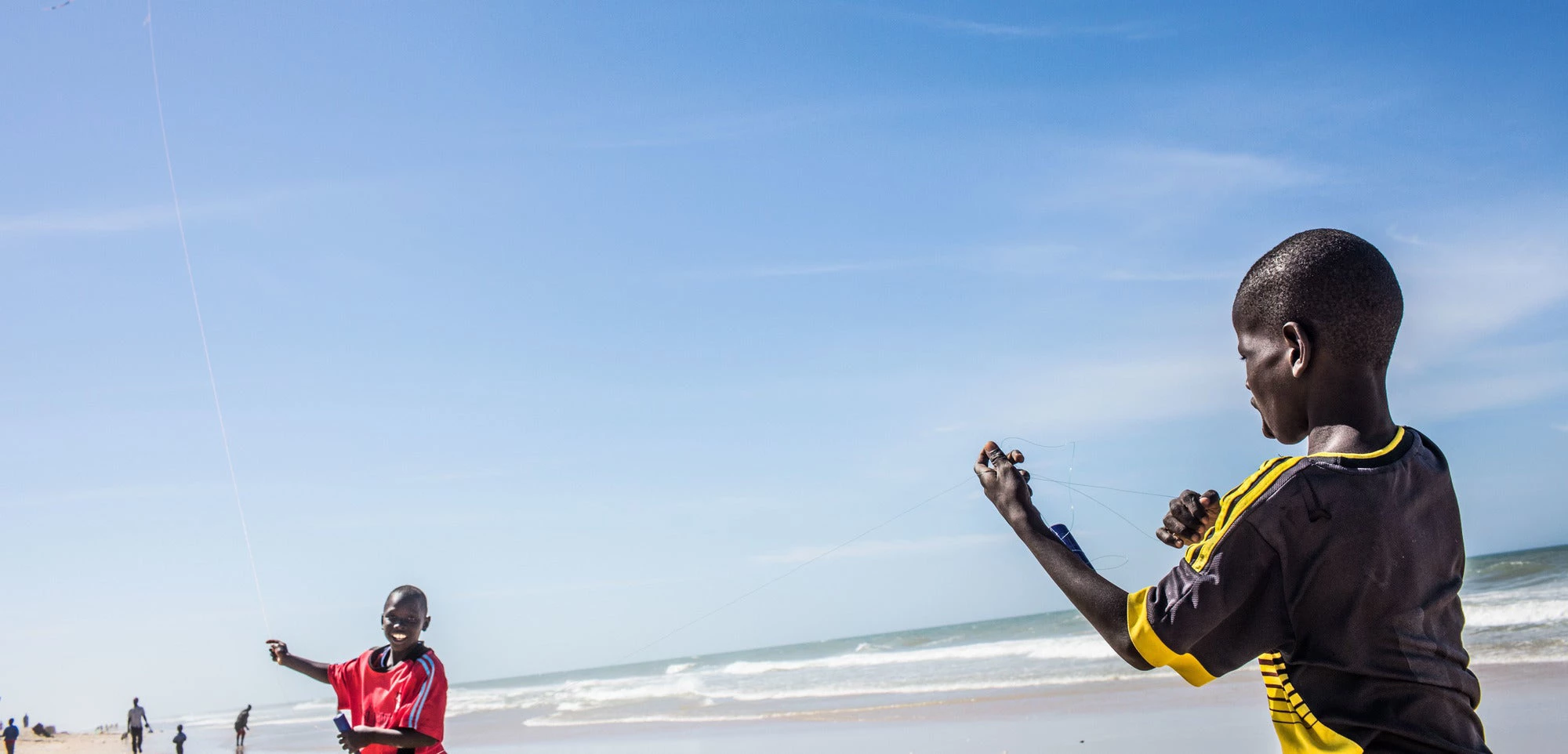 Saint Louis, Senegal. Children play with a kite on a fishermen's pirogue on the beach