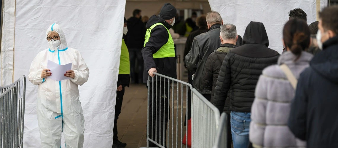 People stand in line in Belgrade, Serbia as they wait to receive a vaccine against COVID-19.