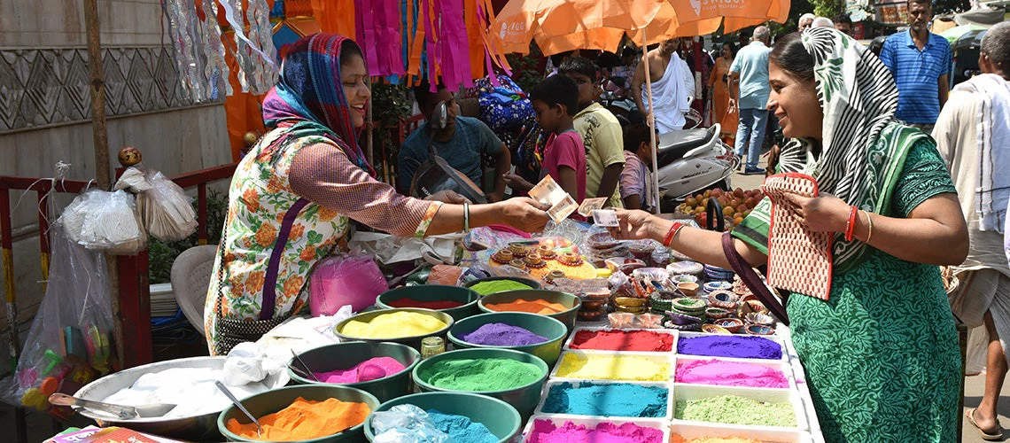 A female shopkeeper and a customer exchanging Rupees at Goregaon market, India | © shutterstock.com