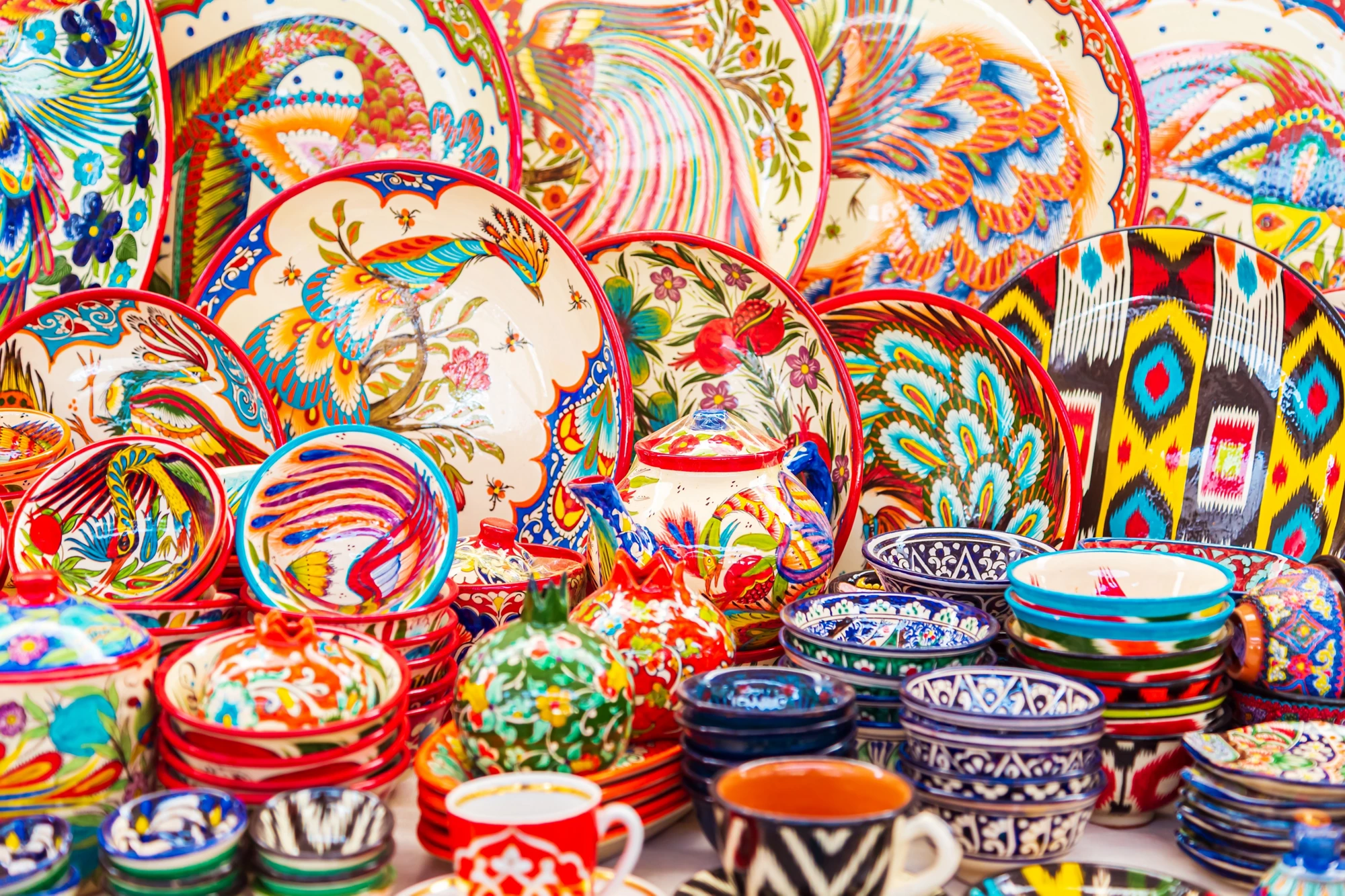 Multicolored ceramic dishes with oriental ornaments at the Siab Bazaar in the ancient city. Samarkand, Uzbekistan - July 20, 2024.