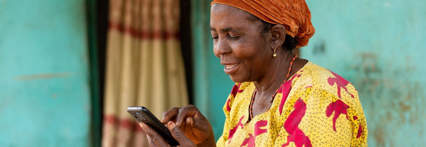 Happy elderly African woman using her mobile phone. Photo credit: Shutterstock.