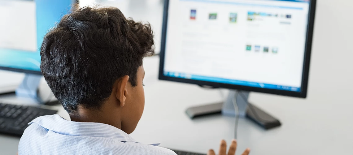 A young buy types on a keyboard.