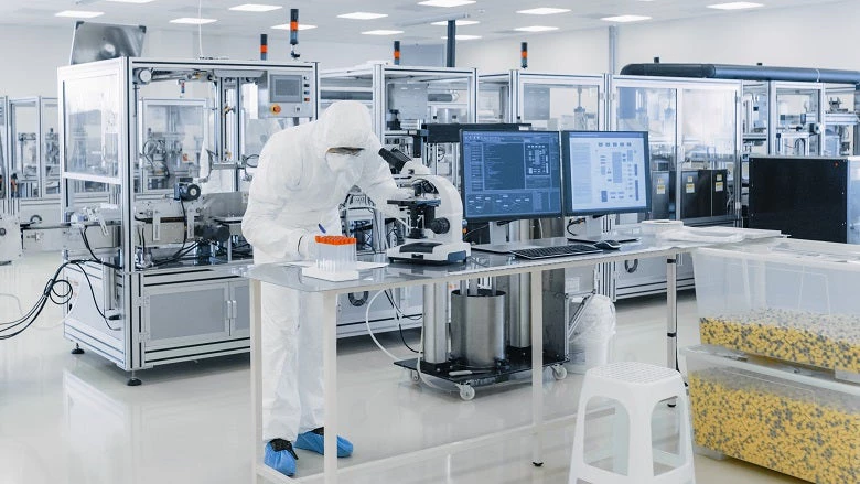 Shot of Sterile Pharmaceutical Manufacturing Laboratory where Scientists in Protective Coverall's Do Research.