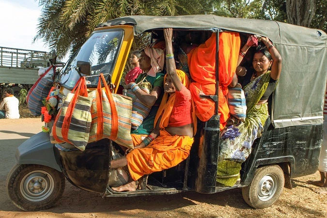 Three wheeler auto rickshaw taxi transports people from haat weekly market to another village at Bastar, Chhattisgarh, India.