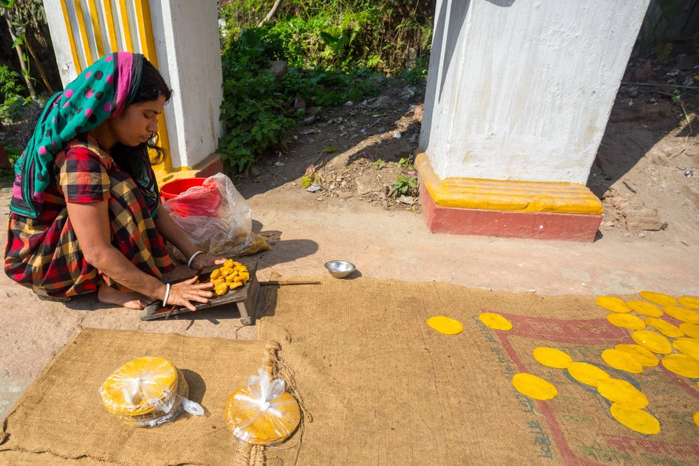 A small business woman making handmade Pappor (deep-fried bread) at Dinajpur Palace, Dinajpur, Bangladesh. Photo: Jahangir Alam Onuchcha / Shutterstock.com