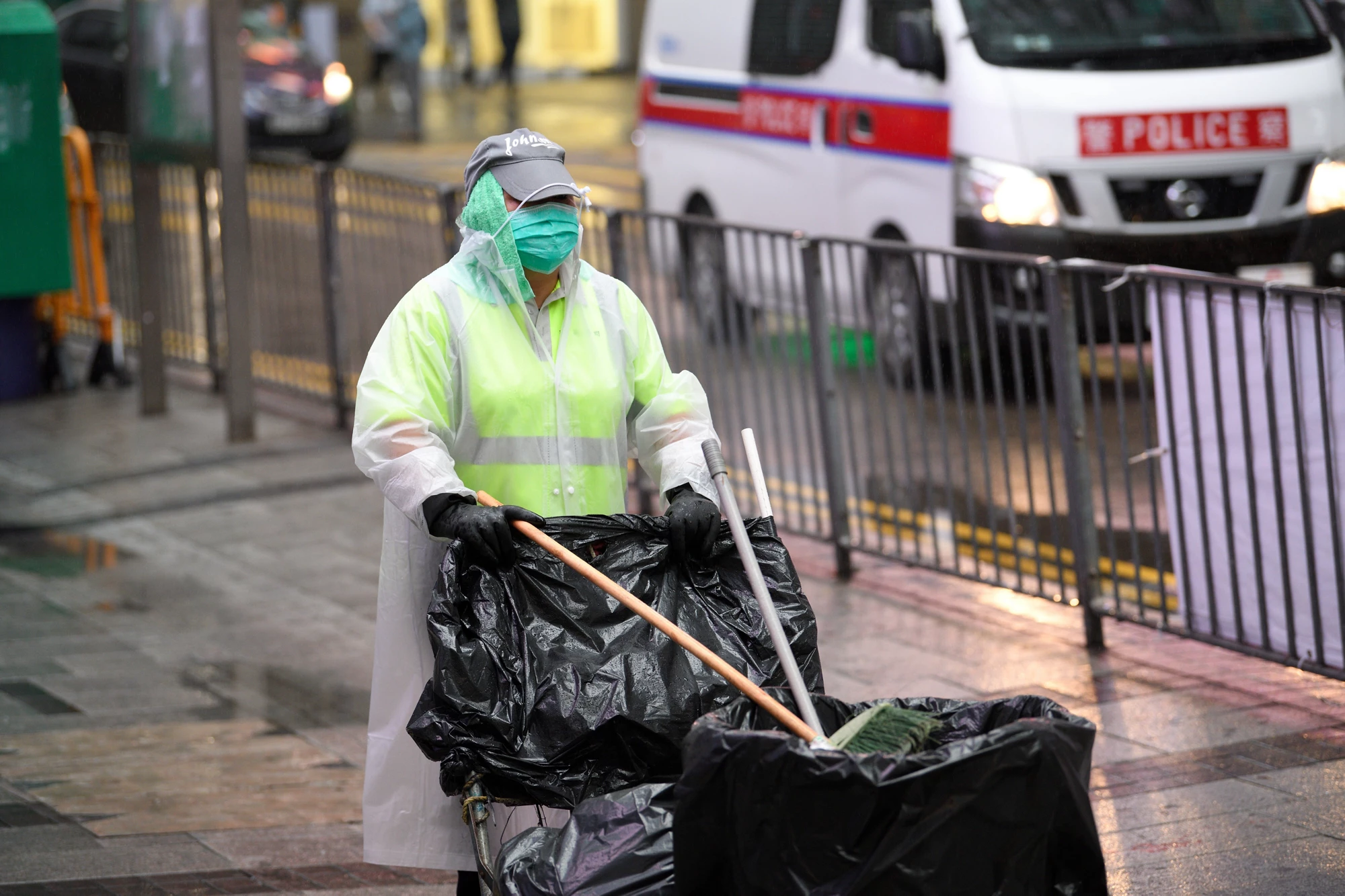 Photo: YT HUI / Shutterstock.com. Waste worker is wearing protective gear on the street in Hong Kong, China. March 2020