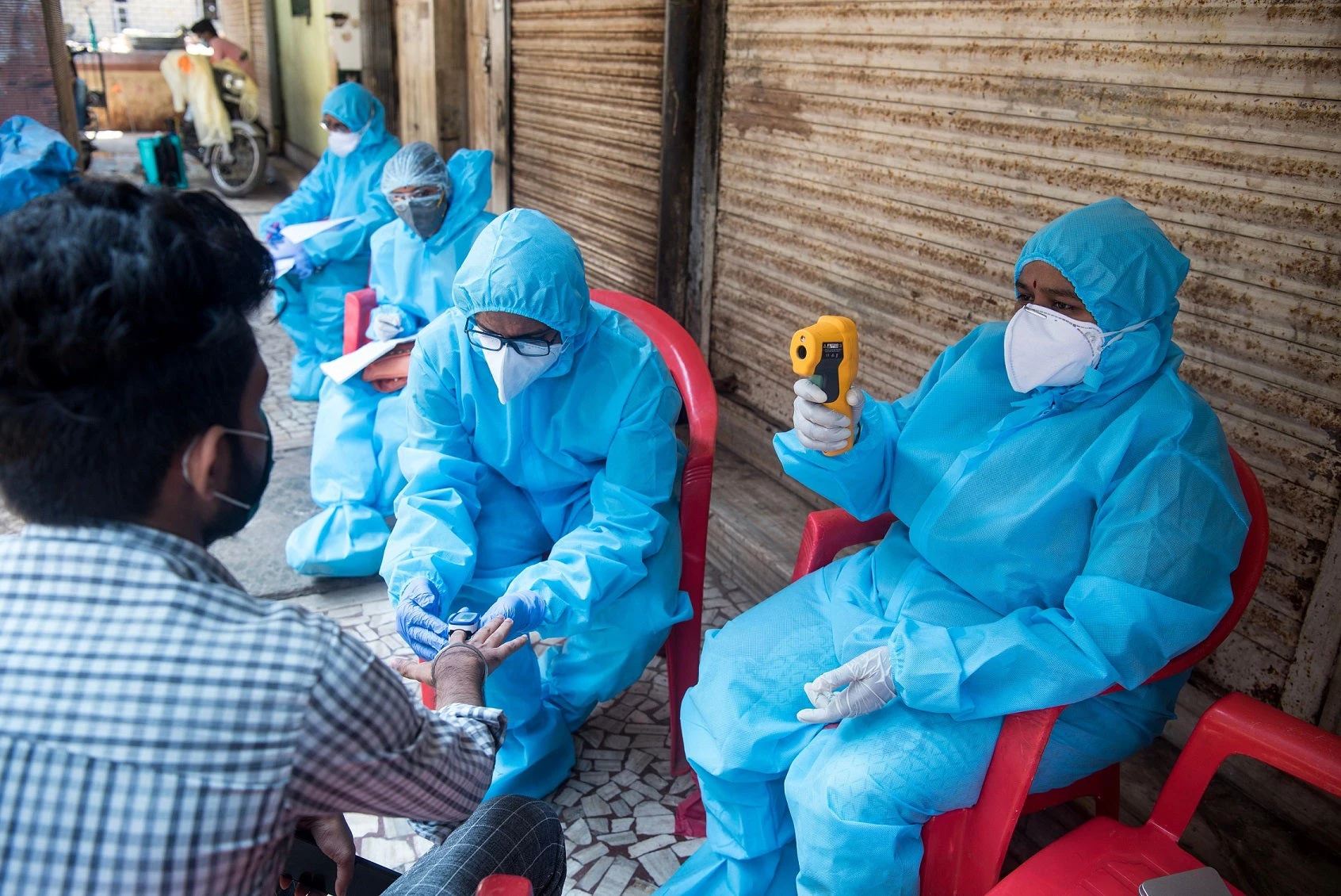 Medical staff wearing protective gear monitor people?s body temperature during COVID-19 testing drive at Dharavi slum in Mumbai, India.