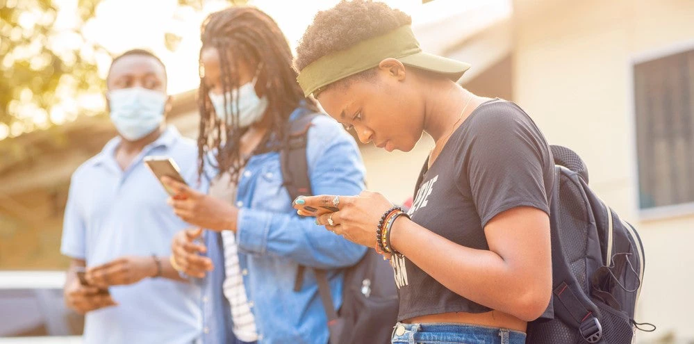Jeunes africains portant des masques et observant le protocole de distance sociale pendant la pandémie de COVID-19.