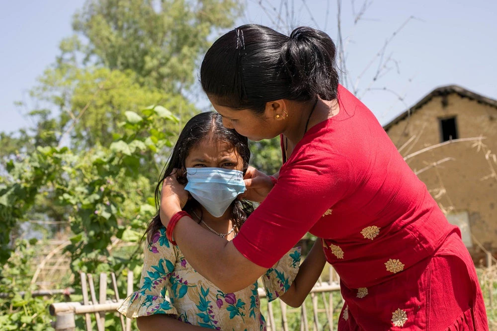 A mother helping her daughter to wear mask in Surkhet, Nepal. Photo: Dipendra Lamsal / Shutterstock.com
