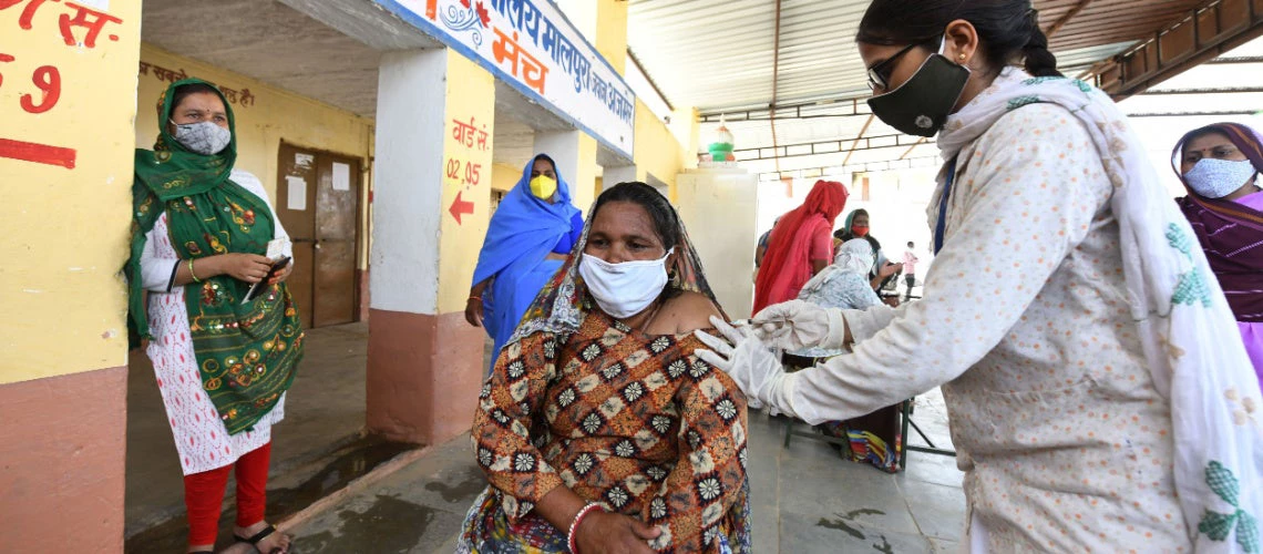 A medic administers the COVID-19 vaccine to a woman at a vaccination centre in Malpura village near Beawar, Rajasthan, India.