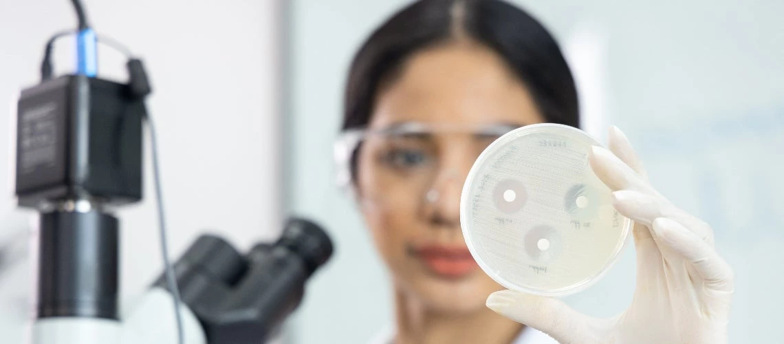 Asian scientist woman are and showing the results of drug resistant in the laboratory room